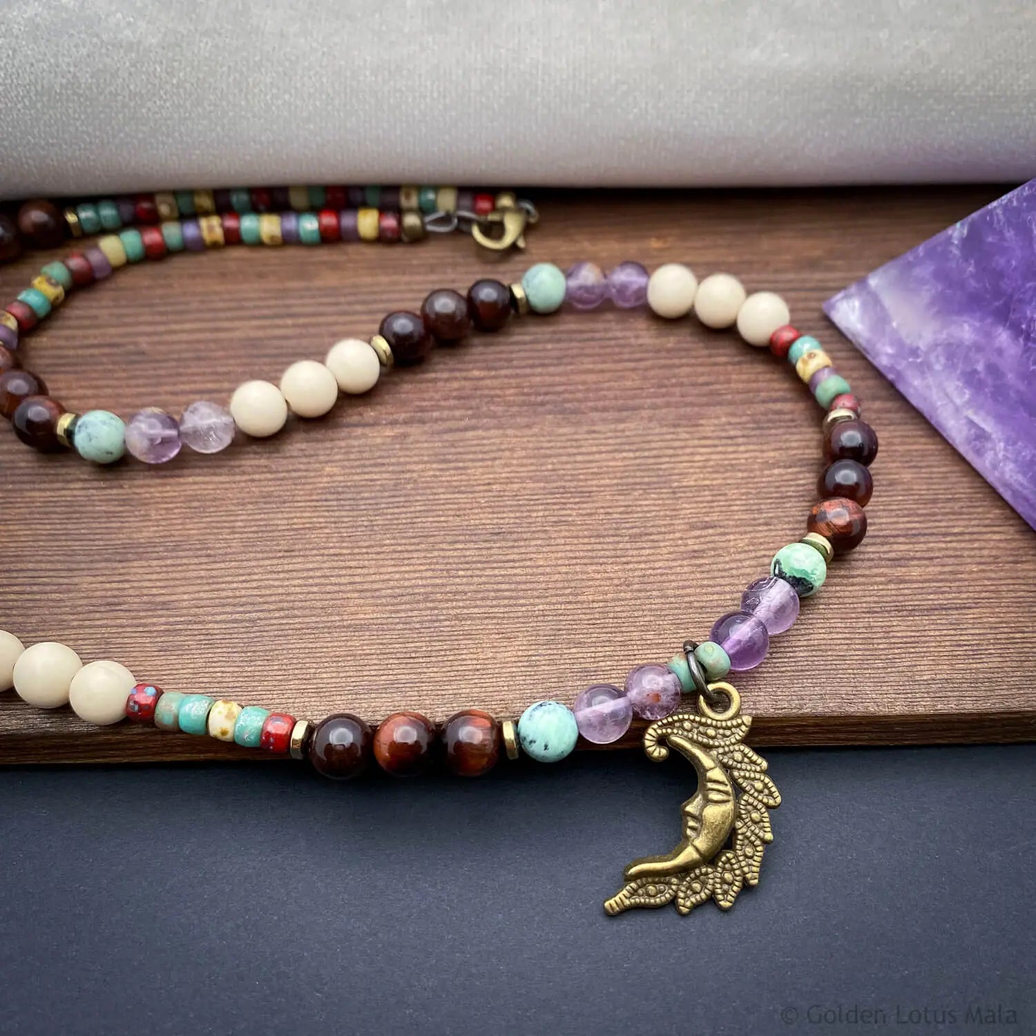 Celestial necklace with quartz, fossil, and tiger eye beads featuring a crescent moon pendant. Natural stone jewelry.