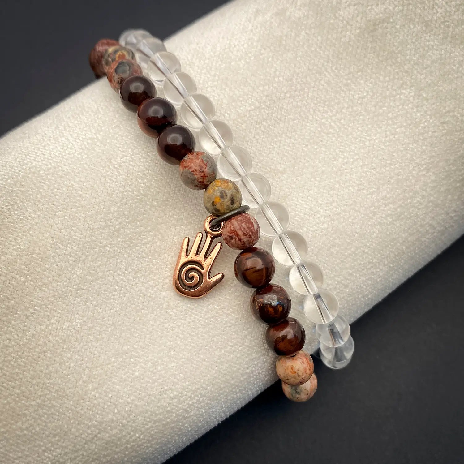 Bracelet with energy hand charm on a gray surface