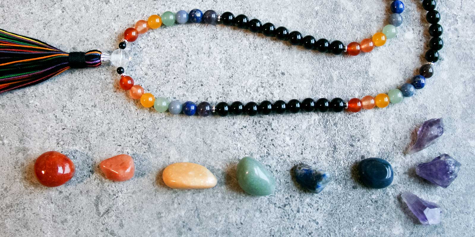 A mala necklace with colors from the Chakras and crystals.