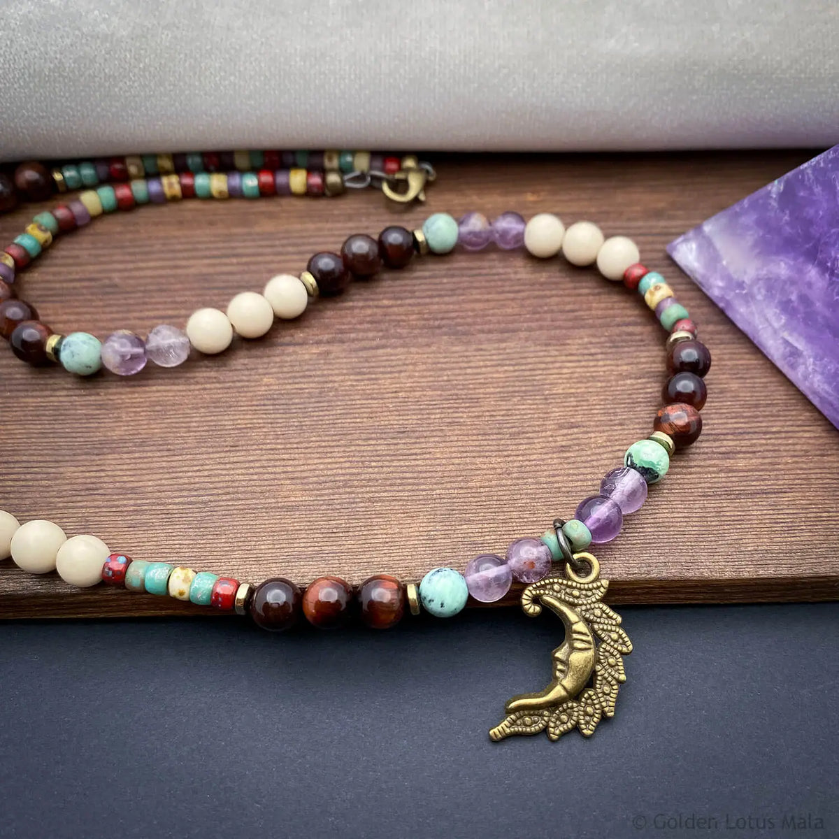 Celestial necklace with quartz, fossil, and tiger eye beads featuring a crescent moon pendant. Natural stone jewelry.