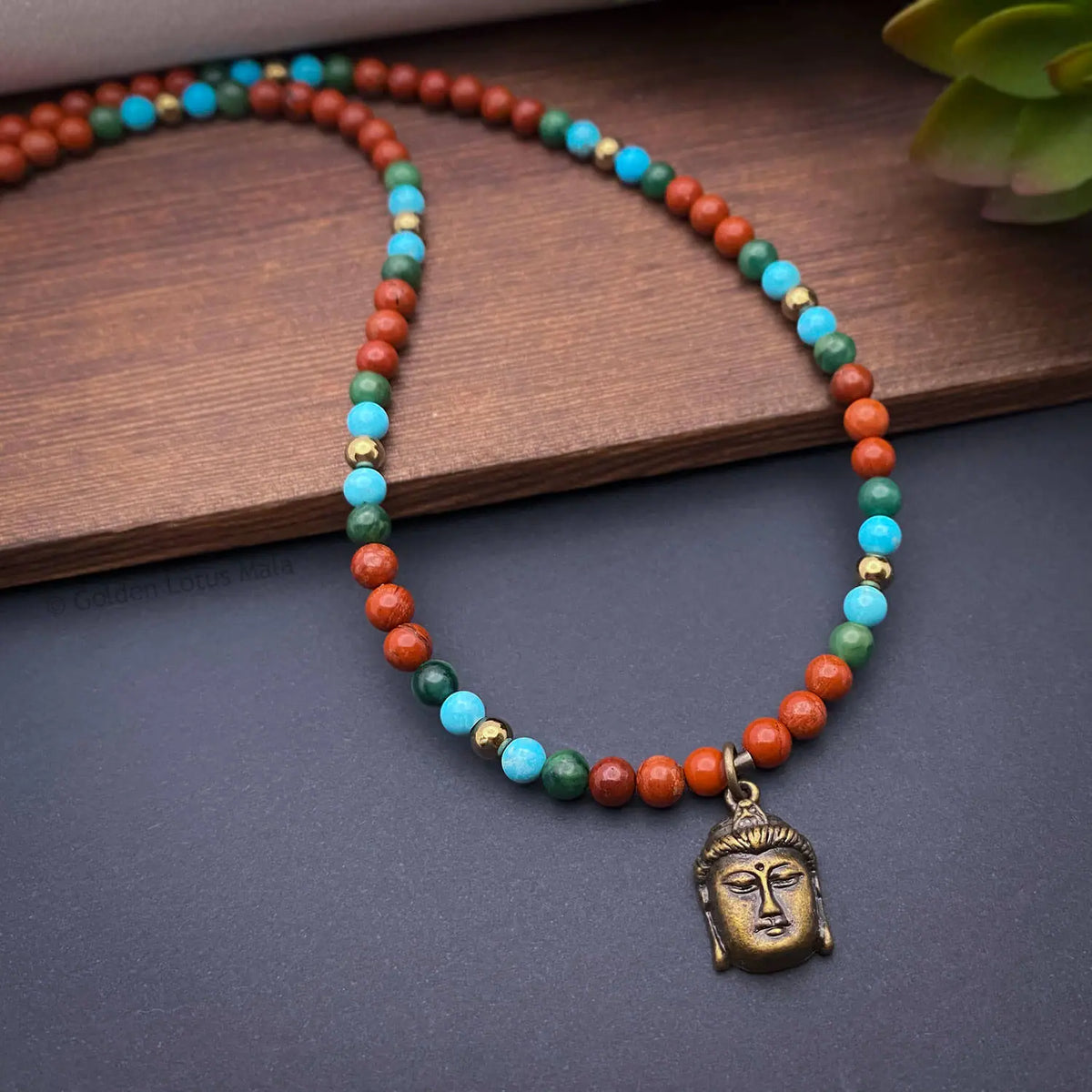 Necklace with multicolored beads and a Buddha pendant on a wooden surface