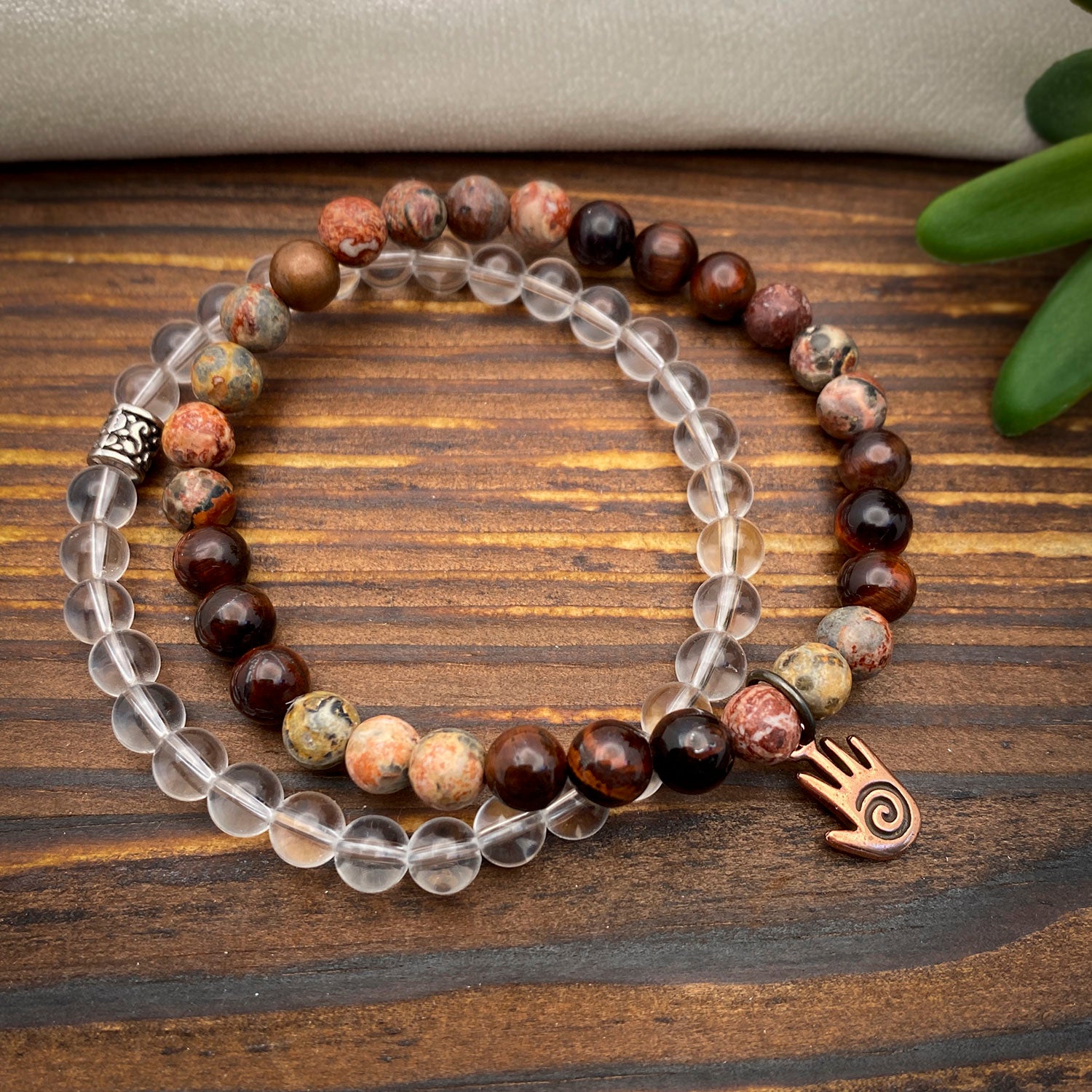 Beaded bracelets with clear and brown beads on a wooden surface