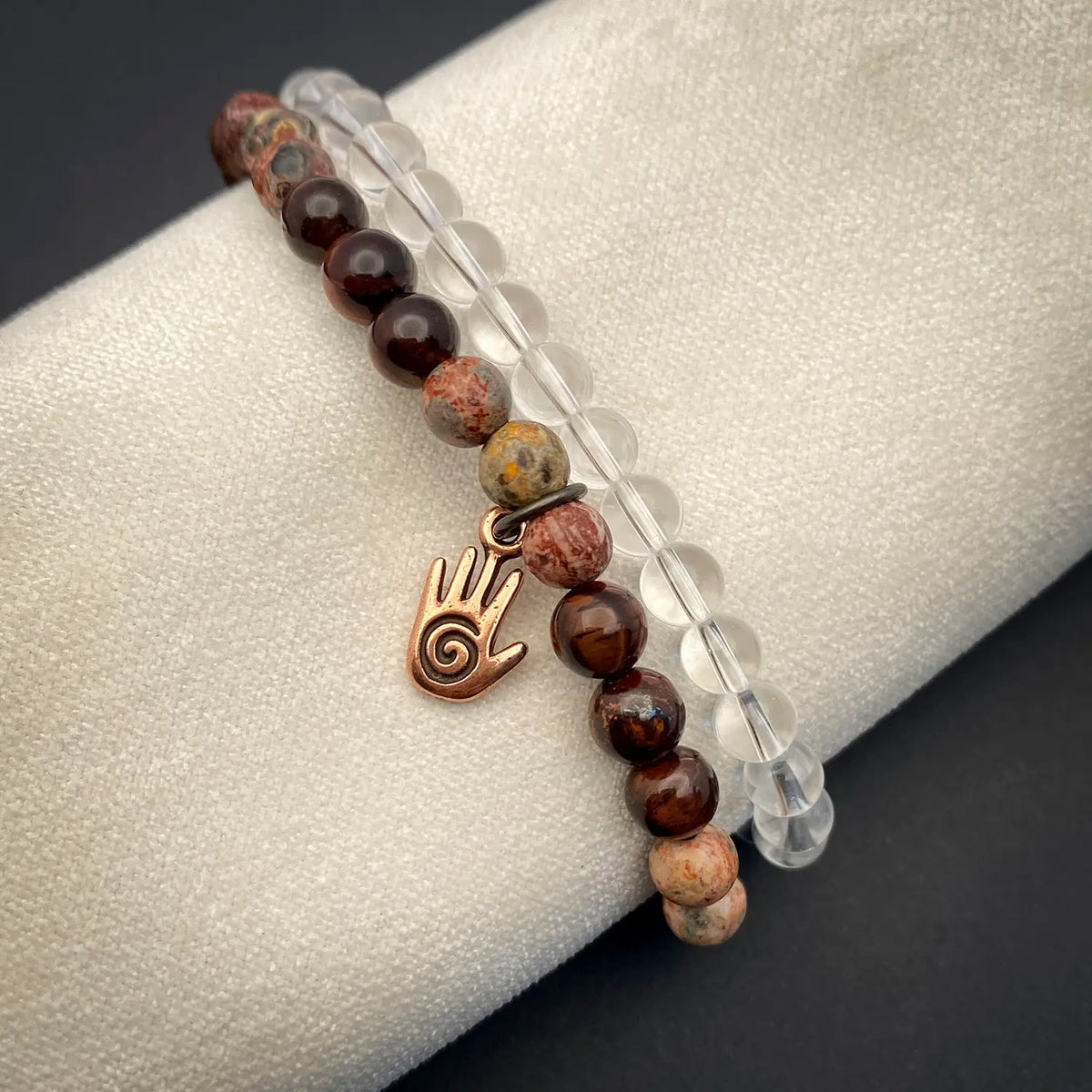 Bracelet with energy hand charm on a gray surface