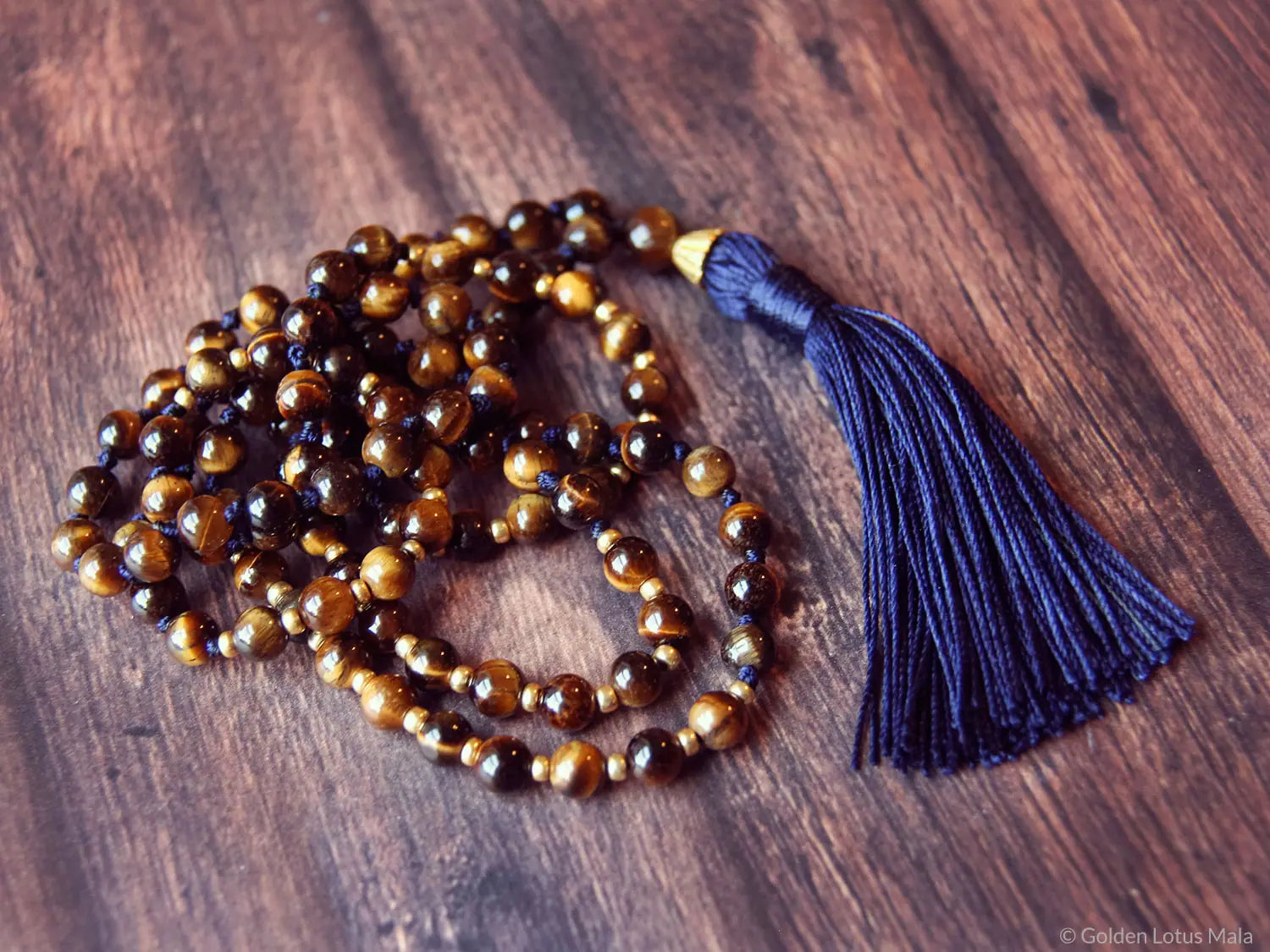 Meditation bead necklace with a blue tassel on a wooden surface